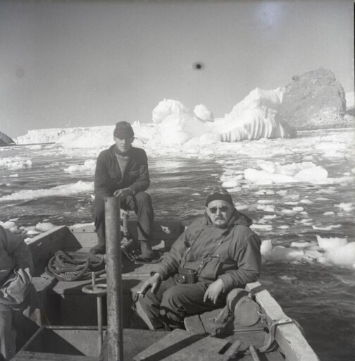 Deux hommes à bord d'une embarcation du Norsel naviguant dans une mer encombrée.