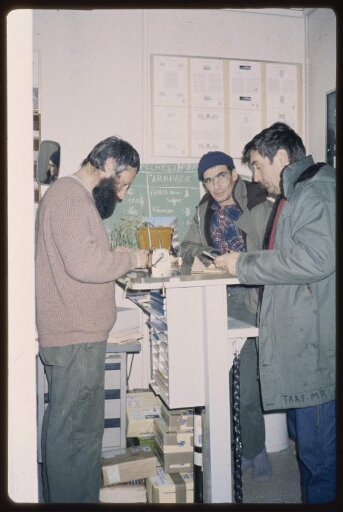 Gestion postale: des hommes debout devant un comptoir. Diapo 5