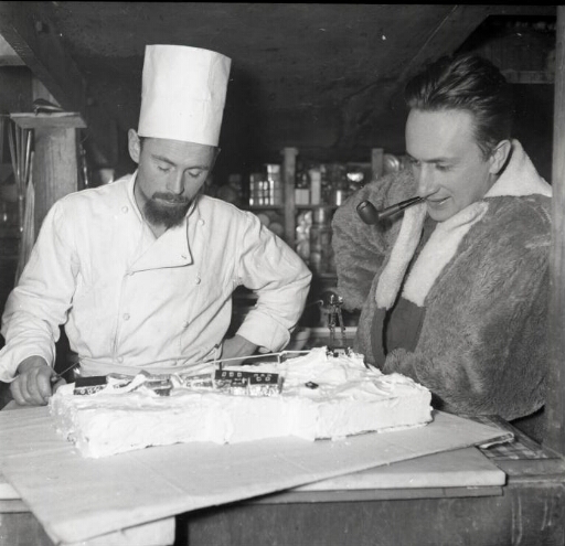 Le cuisinier Raoul Desprez et le chef de mission Michel Barré devant la reconstitution de Port-Martin...en sucre.