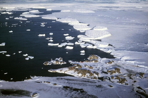 Survol, vers le nord-est, de l'archipel. Le front de l'Astrolabe. Mer en partie prise, nombreux icebergs.