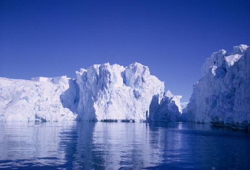 Grands icebergs vus de face, dans une mer libre. Beau temps calme.