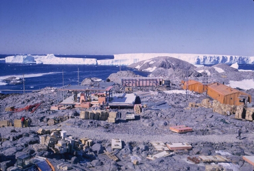 Survol du cœur de la base. Le bâtiment séjour en construction, la nouvelle centrale et la base AGI. En arrière plan le glacier de l'Astrolabe.