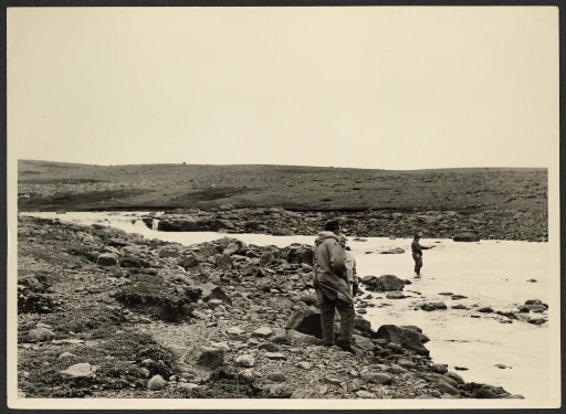 Trois hommes au bord de la Rivière du Sud avec sa cascade