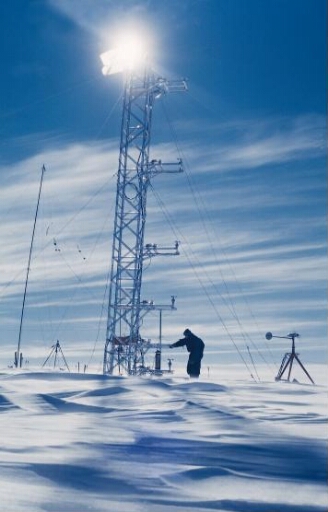 L'un des trois hivernants inspecte les équipements de mesures installés sur la tour de micrométéorologie qui éclipse le soleil....