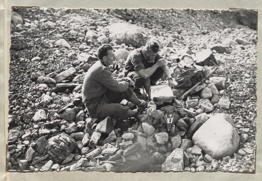 Jean Corbel et Mr Dussuet assis sur des roches et regardant une carte
