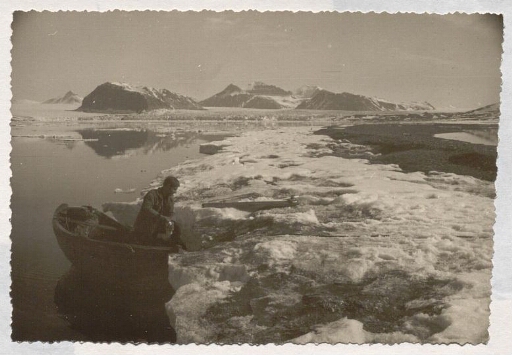 Un homme sur une barque qui est accosté sur le bord de glace