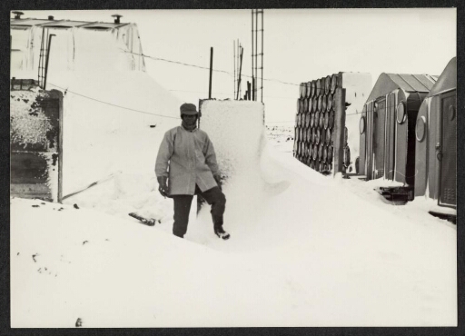 Un homme dans la neige à côté des bâtiments d'Alfred Faure