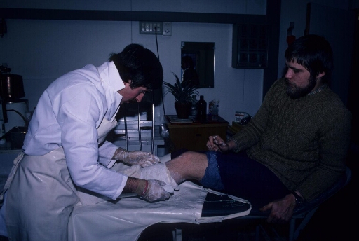 Au cours de l'hivernage, le médecin Bruno Pats confectionne un plâtre sur la jambe gauche de son patient.