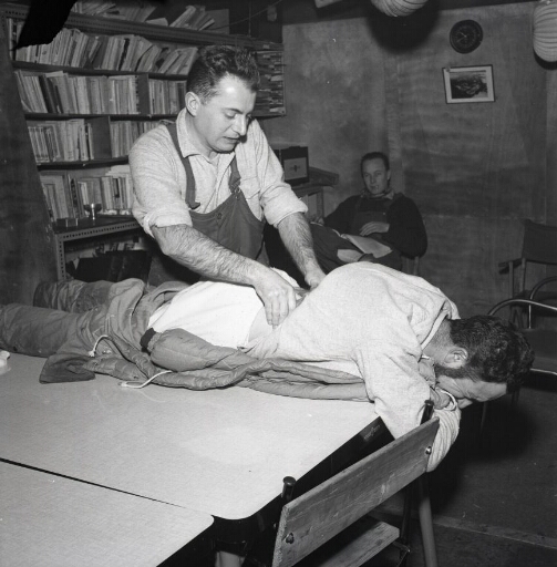 Le médecin Gilbert Goy massant le dos de son patient, l'ingénieur de base Fernand Jardel.
