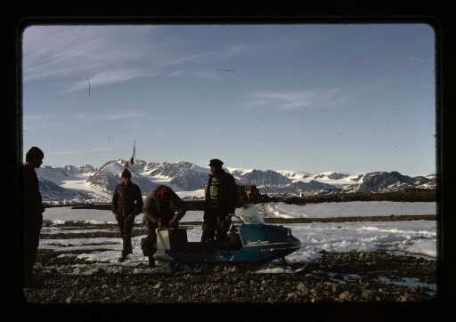 Groupe de personne près d'un skidoo près du glacier - mission CNRS 1966