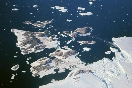 Survol, vers le nord, de l'archipel. Mer libre, quelques glaçons, le front du glacier de l'Astrolabe.