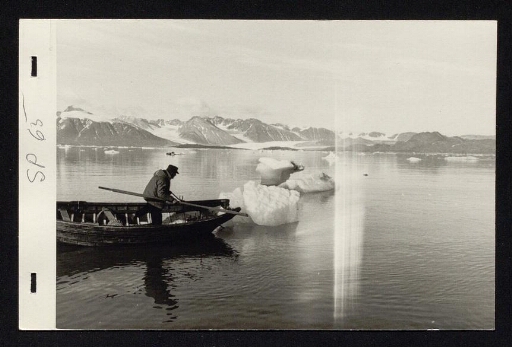 Un homme sur une barque avec des morceaux de glaces