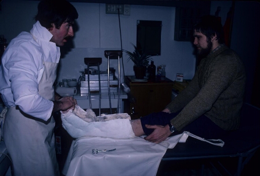 Au cours de l'hivernage, le médecin Bruno Pats confectionne un plâtre sur la jambe gauche de son patient.