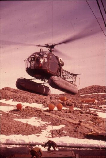 L'hélicoptère Alouette 2 utilisé en grue volante pour le transport et la mise en place des matériaux de construction.