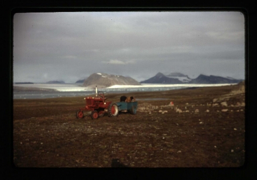 Deux hommes dans la toundra près d'un tracteur rouge et d'une remorque bleue - mission CNRS 1964