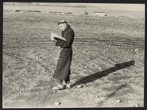 Un moine (un homme déguisé?)marchant avec un livre dans les mains