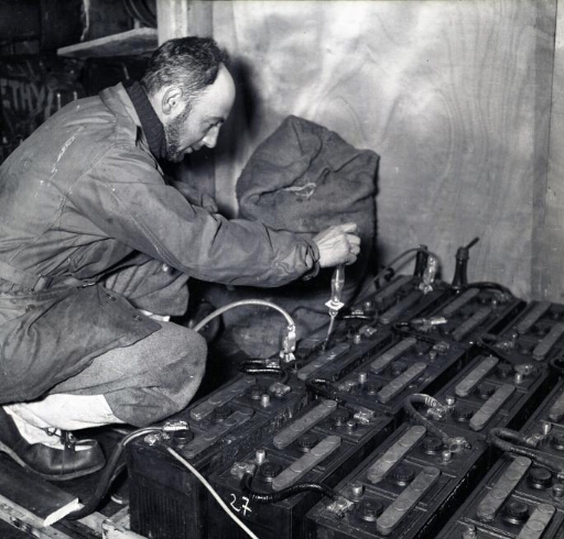 L'ingénieur de base, Jacques Dubois complète le niveau d'électrolyte d'une batterie.