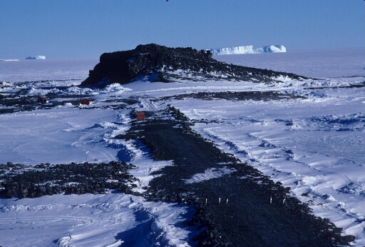 La piste du Lion en hiver, le chantier en attente... La banquise à perte de vue et au loin un gros iceberg tabulaire.