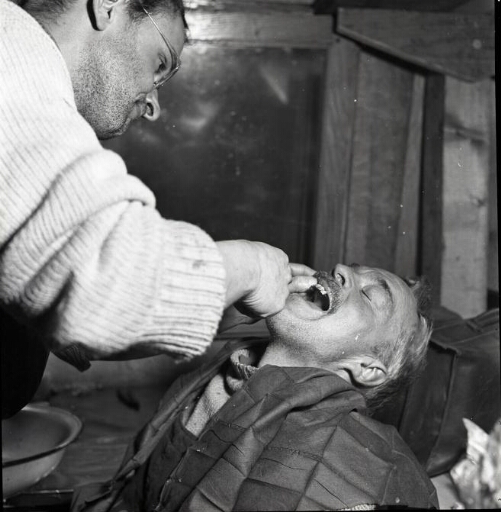 Le médecin Jean Sapin-Jaloustre donne des soins dentaires à André Paget, menuisier-charpentier.