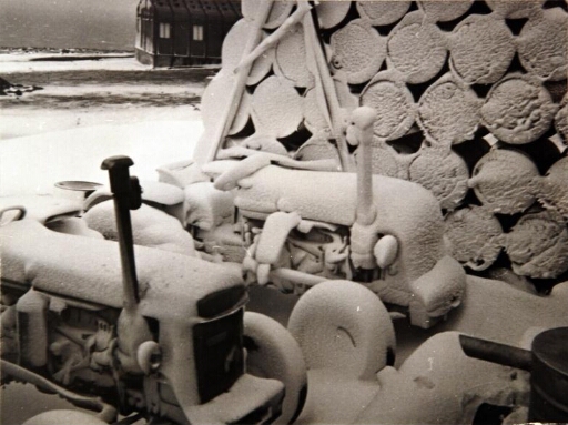 Deux tracteurs et du matériel couverts de neige