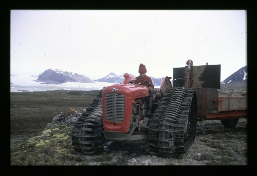 Une personne au volant d'un tracteur à chenilles près d'un fjord - mission CNRS 1964