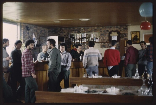 Un groupe de personnes à un repas collectif  (lieu près du bar). Diapo 1