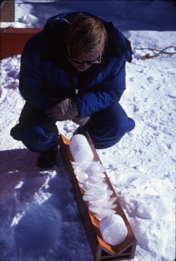 A Dôme C, le chantier de forage glaciologique profond : l'un des glaciologues examine une carotte de glace.
