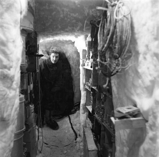 Le glaciologue Claude Lorius dans la galerie creusée dans le névé et dans laquelle se trouve entrepôt, laboratoire et toilettes.