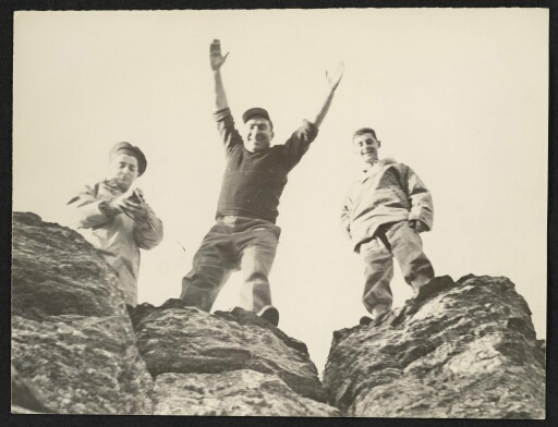 Trois hommes regardant l'objectif d'en haut d'une falaise