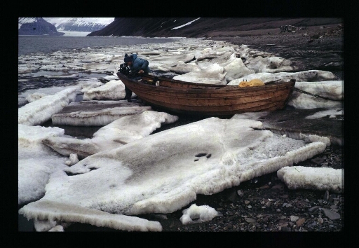 Un homme prépare une barque pour partir sur le fjord - mission CNRS 1965