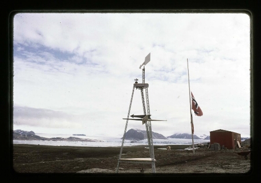 Vue sur un drapeau et des petites girouettes près d'un bâtiment rouge- mission CNRS 1965