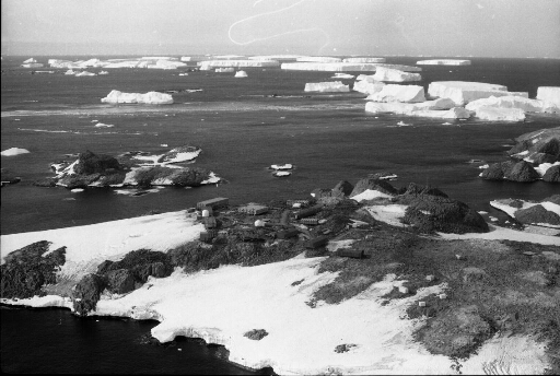 Survol vers le nord-est des îles des Pétrels, du Lion et Buffon. Nombreux icebergs tabulaires.