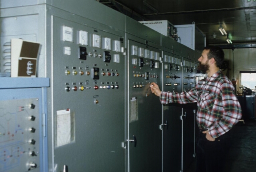 Dans la centrale électrique (Bt n°24), un électrotechnicien contrôle le fonctionnement de l'un des quatre groupes électrogènes.