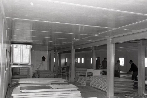 Aménagements intérieurs du bâtiment logement hivernage (n°42) : 4 hommes posent les cloisons Spair.