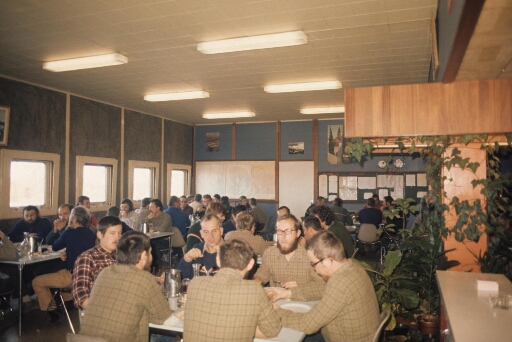 La salle à manger du bâtiment séjour (Bt n°31). Pendant la campagne d'été 1973 sont réunis à table : l'équipe été 1973 et les hivernants 1972 et 73.