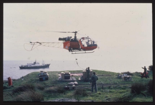 Un hélicoptère dépose du matériel sur la zone dédiée. A l'arrière plan, le Marion Dufresne. 