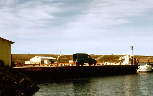 La base de Port aux Français vue de la mer (PAF) avec Les installations du port et le dodge de la marine,  la Japonaise à quai et la route qui monte à la météo et géophy