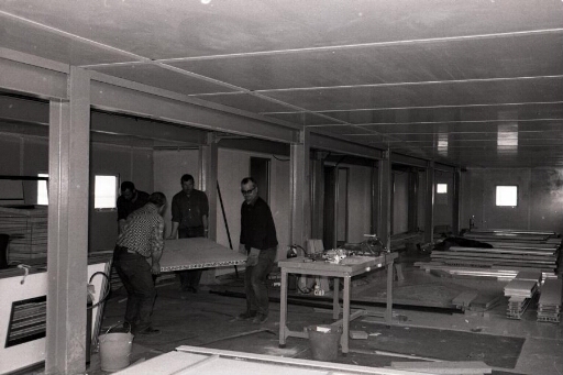 Aménagements intérieurs du bâtiment logement hivernage (n°42) : 4 hommes posent les cloisons Spair.
