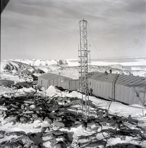 Les deux premiers bâtiments de la base Dumont d'Urville. Au loin le glacier de l'Astrolabe et des icebergs.