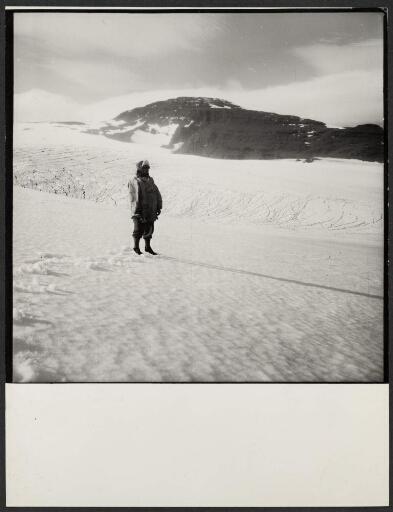 Un homme debout à côté d'une langue de glacier