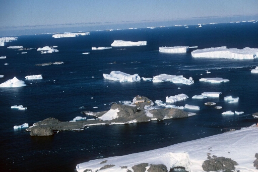 Vue aérienne du chantier de construction de la piste d'atterrissage sur l'île du Lion. Mer libre et nombreux icebergs à perte de vue.