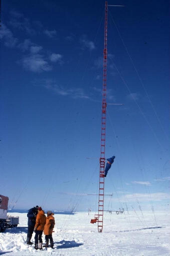 Programme IAGO pour l'étude des vents catabatiques. Sur le continent, à D 10, montage du pylône aérologique, pose des haubans. La côte à l'horizon.