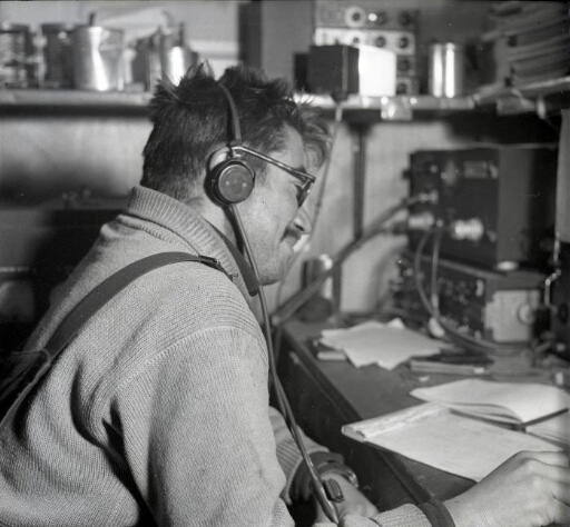 Maurice Harders , opérateur radio,casque sur la tête pendant une vacation "graphie" (morse).