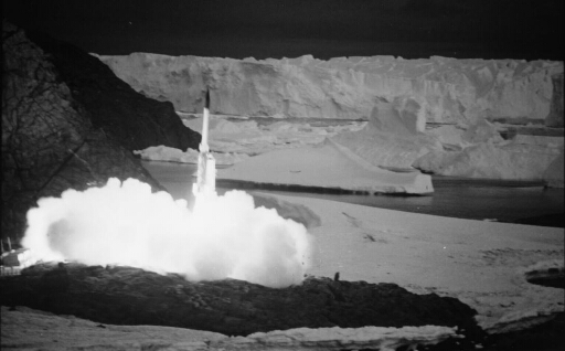 Tir nocturne de l'une des quatre fusées Dragon sur fond de glacier de l'Astrolabe.