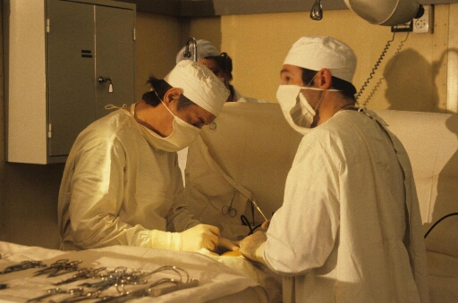 Intervention chirurgicale : au cours de la campagne d'été, dans la salle opération de l'infirmerie, médecin(s) et assistants autour de leur patient.