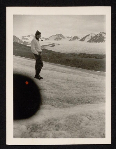 Un membre de l'équipe de Jean Corbel qui fume la pipe sur le flanc d'une montagne- mission CNRS 1963