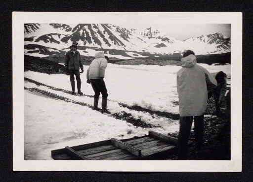 Trois hommes travaillent dehors sur l'île du Spitzberg;  mission CNRS 1964