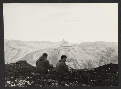 Deux hommes assis sur une falaise avec vue sur la vallée