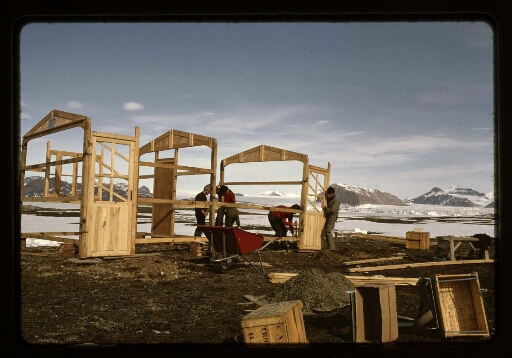 Des hommes construisent un bâtiment en bois à la base Corbel - mission CNRS 1965