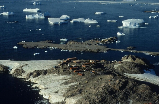 Survol, vers le nord-nord-est, de l'île des Pétrels et le chantier de la piste du Lion. Mer libre, petits icebergs.